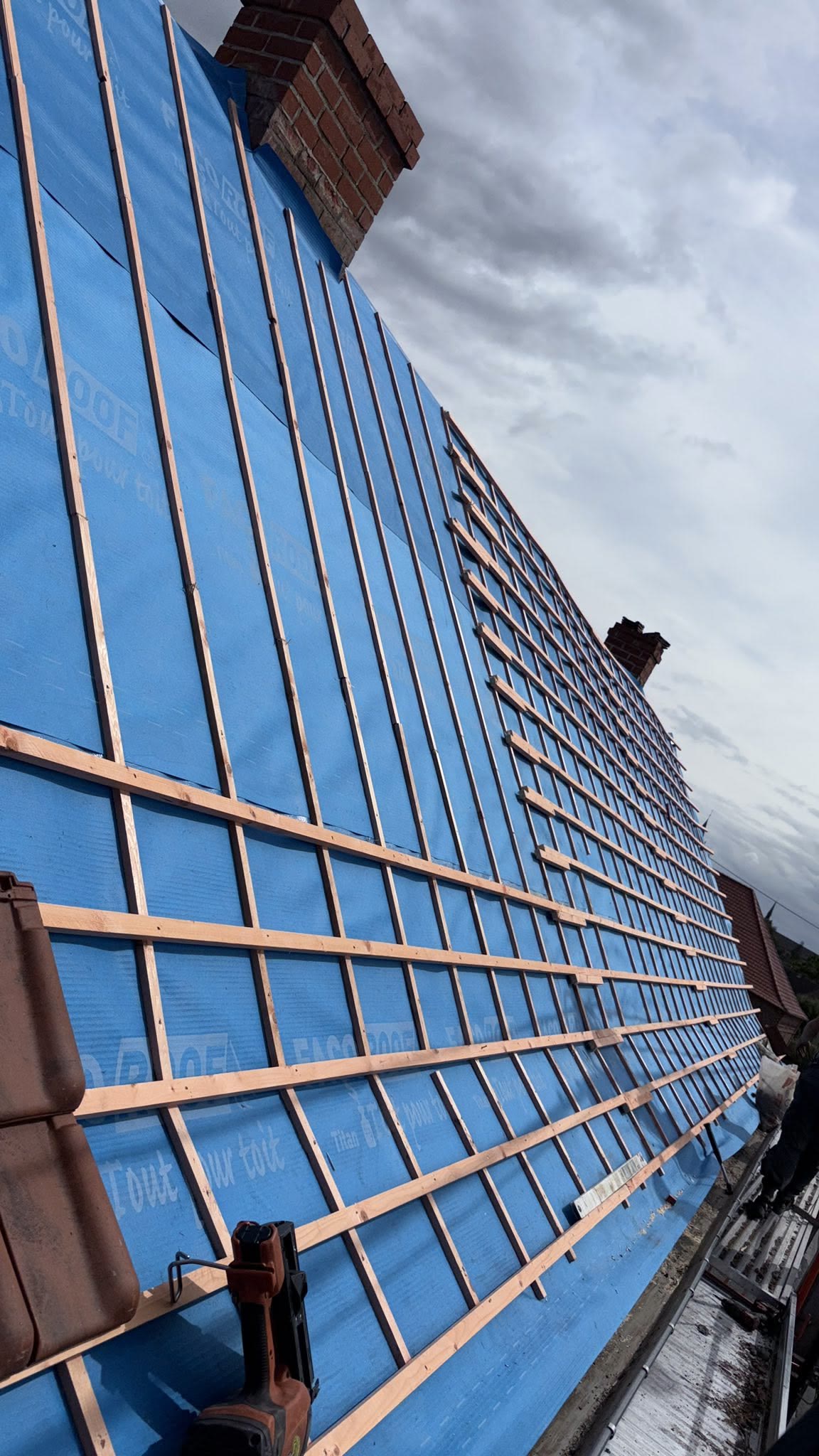 Sous-toiture bleue recouverte de liteaux en bois