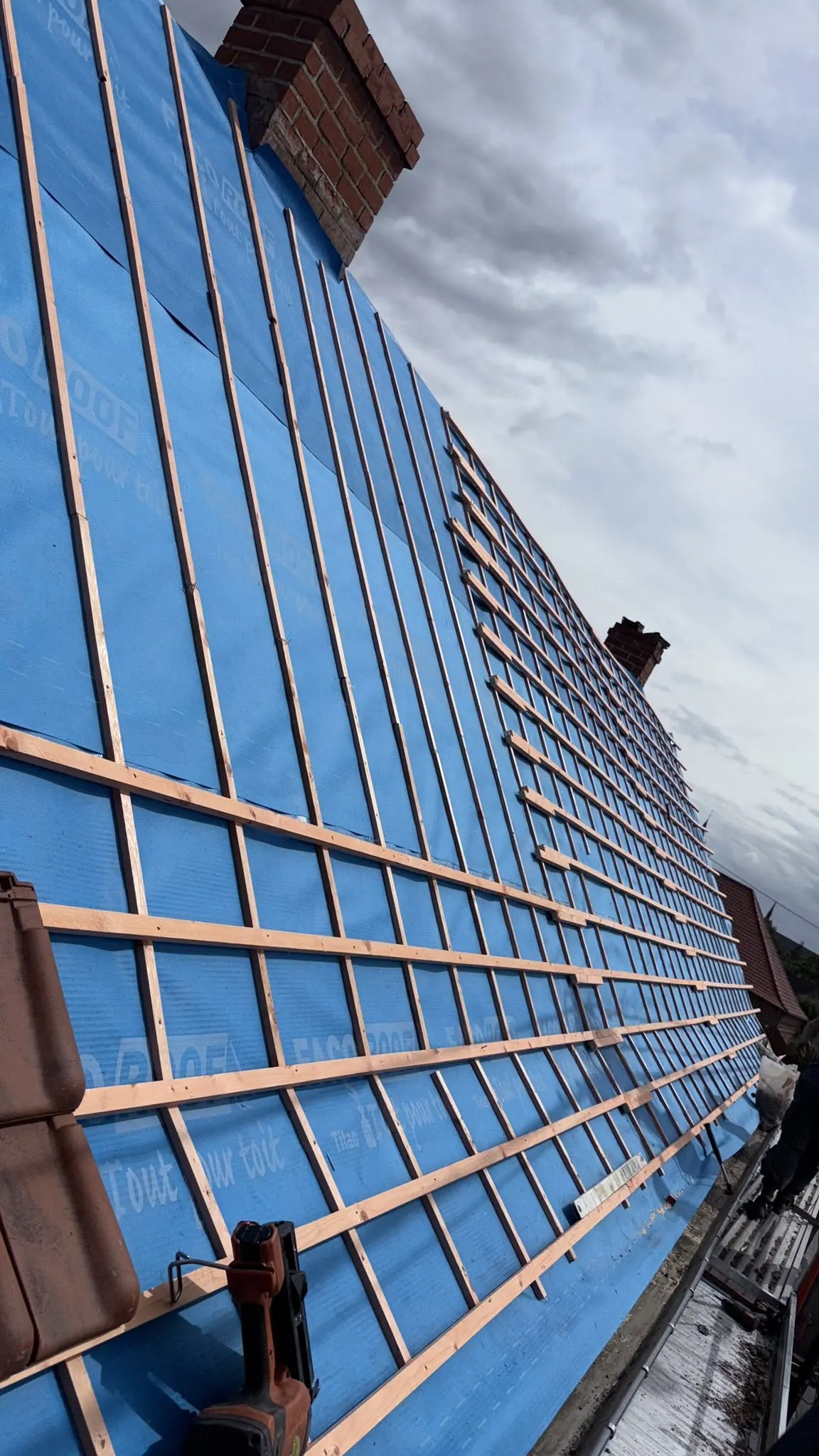 Sous-toiture bleue recouverte de liteaux en bois
